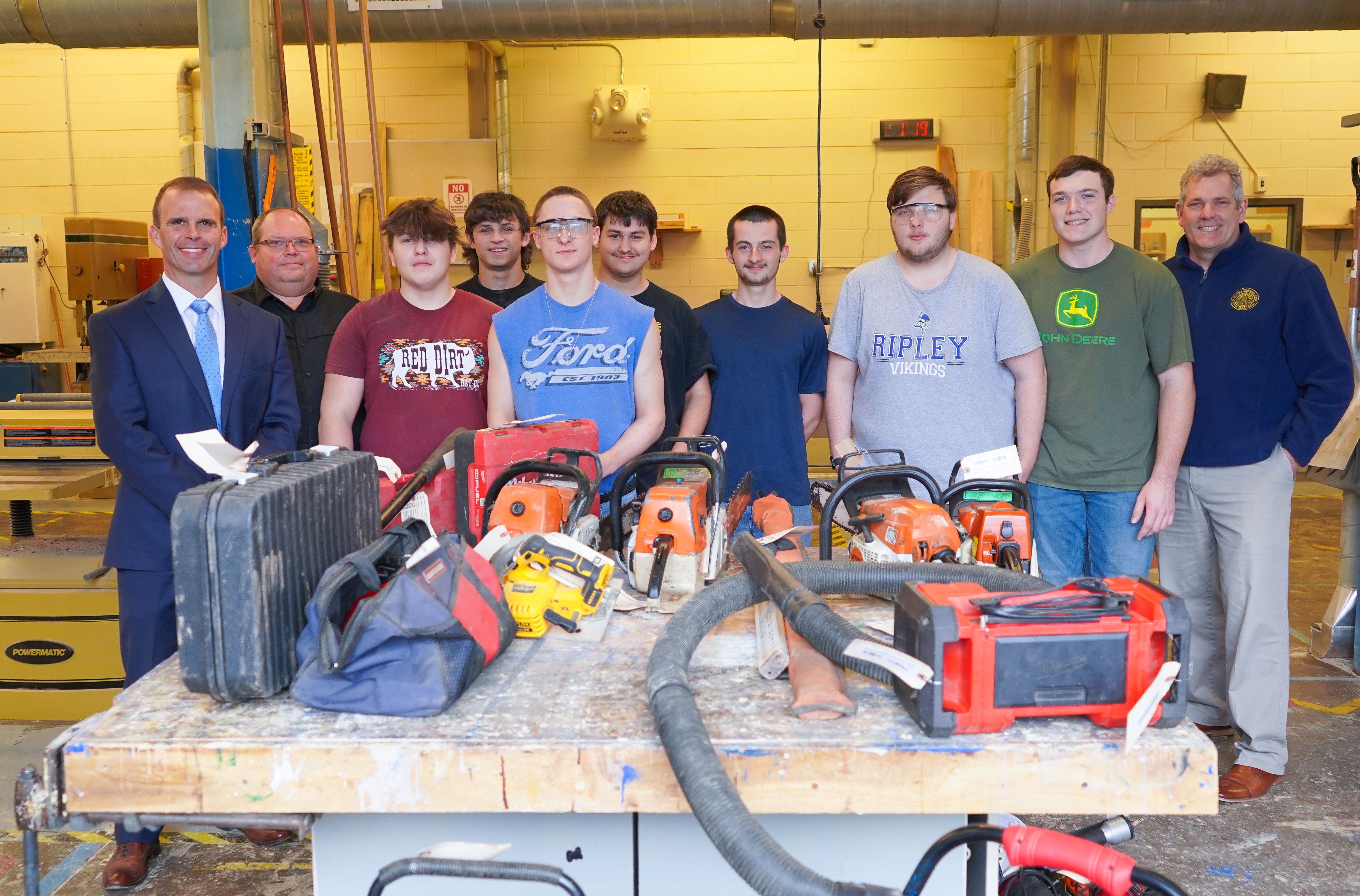 students posing with tools